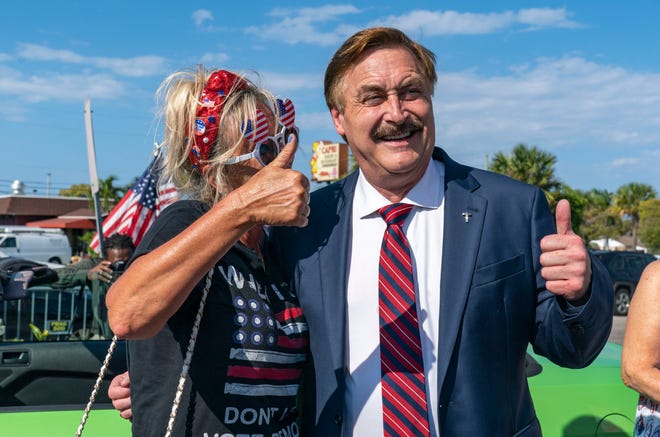Mike Lindell, the My Pillow Inc chief executive poses withTrump supporters as they wait along the motorcade route for former President Donald Trump to  return home to Mar-a Lago following his arraignment in New York on April 4, 2023.