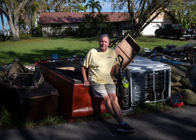 In this October photo, Rod Quinlan sits on an overturned sofa from his house on the Caloosahatchee River that was flooded in the storm surge from Hurricane Ian. Quinlan said the flood, which destroyed everything they own, was like salt in a wound since his wife Cynthia has terminal cancer.