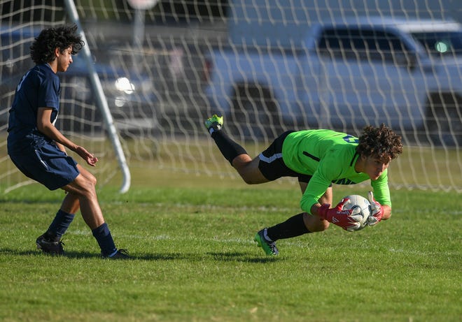 The Pine School goalkeeper Javi Barbosa (right) makes the save ahead of St. Lucie West Centennial's Chris Djambazian during the first half of their boys soccer match at St. Lucie West Centennial High School on Wednesday, Jan. 11, 2023, in Port St. Lucie. The game ended in a draw 1-1.