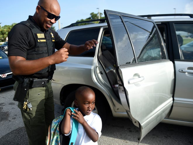 Indian River County Sheriff's Capt. Milo Thornton greets students in the car loop at Vero Beach Elementary School on Wednesday, Aug. 10, 2022. Students returned from summer break to fully in-person classes with no mask mandate.