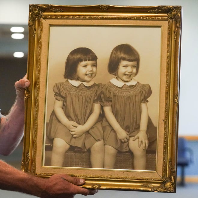A framed photograph of identical twin sisters Cathy (left) and Frances Julia Slater is held by Eric Wojcieszak, the twin's nephew, after J.B. "Pig" Parker was sentenced to life in prison with the possibility of parole after 25 years, Friday, March, 31, 2023, at the Martin County Courthouse in Stuart. Parker is one of four men convicted of the April 2, 1982, murder of Frances, who was kidnapped shortly before midnight while working at a convenience store on U.S. 1 in north Stuart. Slater, of Jensen Beach, was later shot and stabbed off Kanner Highway west of Stuart. Parker was sentenced to death in 1983 after an 8-4 jury vote. In a second sentencing phase in 2000, a different jury favored execution 11-1.