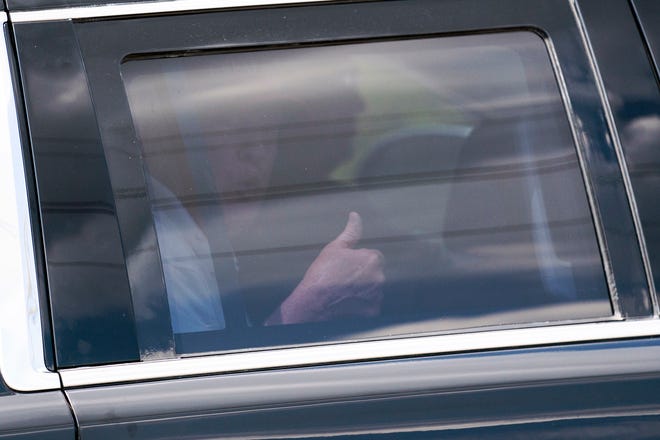 A motorcade carrying former President Donald Trump gives a thumbs up as he leaves Trump International Golf Club, Sunday, April 2, 2023, in West Palm Beach, Fla. (AP Photo/Evan Vucci) ORG XMIT: FLEV101