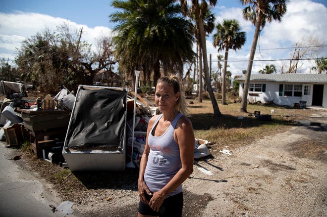 Rachel Helgerson stands outside her rental home on Monday, Oct. 17, 2022. All of her things are sitting on the curb after the flooding from Hurricane Ian ruined everything. "I've started over a few times. I'll do it again," Helgerson said.