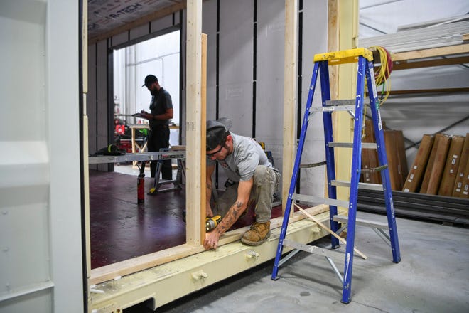 Containing Luxury employee Dom Epting, of Palm City, works on a window frame while building a container home, Friday, March 17, 2023, at 4402 SW Port Way in Palm City. The company converts steel shipping containers into tiny homes and is one of more than 100 businesses in the tri-county area that is a Second Chance employer, which seeks to hire some people looking for a fresh start after coming out of prison, participating in a diversion court program, or who are in recovery.