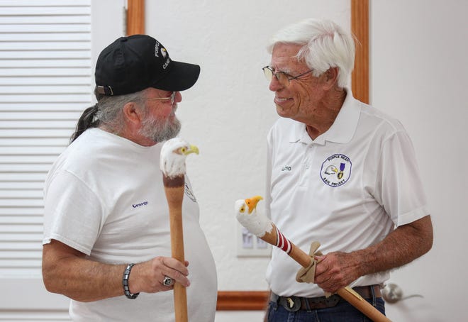 George Stukshis (left), of Fort Pierce, a board member with the Purple Heart Cane Project, and Lloyd Lasenby, president and cofounder of the Purple Heart Cane Project, speak about their eagle head carvings during a gathering of veterans and civilians who meet every Tuesday at the Spanish Lakes Fairways clubhouse on Tuesday, April 4, 2023, in Fort Pierce. The non-profit group carves canes for those who served and were wounded in combat against a foreign nation.