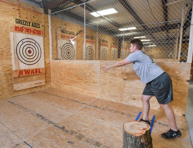 Owner Jeff Fischer demonstrates his ax throwing technique at Grizzly Axes on N Davis Highway in Pensacola on Monday, July 15, 2019.