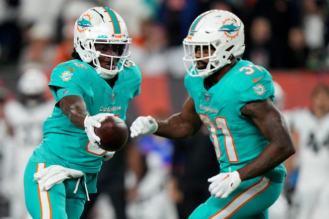 Sep 29, 2022; Cincinnati, Ohio, USA; Miami Dolphins quarterback Teddy Bridgewater (5) play-action fakes to Miami Dolphins running back Raheem Mostert (31) in the fourth quarter during a Week 4 NFL football game against the Cincinnati Bengals, Thursday, Sept. 29, 2022, at Paycor Stadium in Cincinnati. The Cincinnati Bengals won, 27-15 to improve to 2-2 on the season.  Mandatory Credit: Kareem Elgazzar-USA TODAY Sports