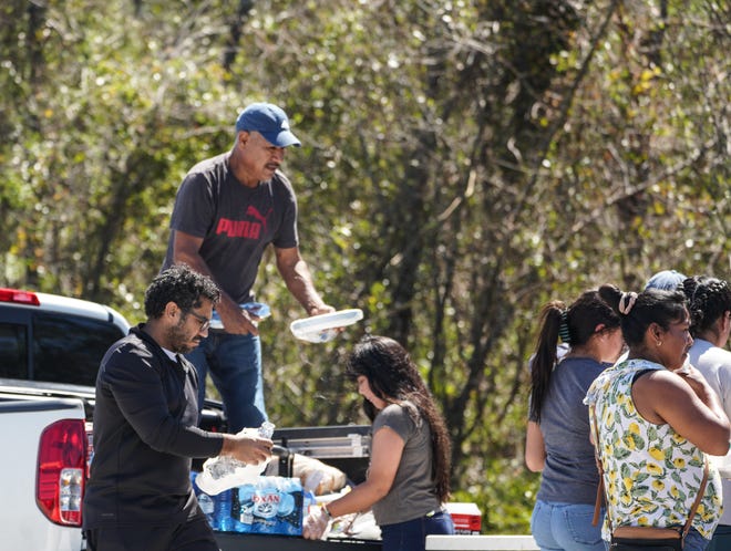 Volunteers hand out food in a flooded area of DeSoto County, Fla., in the days after Hurricane Ian.