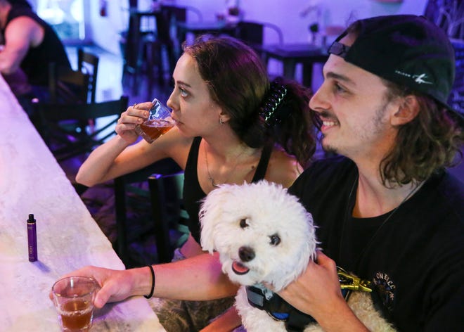 McKenzie Lester (left), of Jensen Beach, and Jacob Jerome, of Melbourne, drink hot white kratom tea shots Friday, Aug. 26, 2022, at Island Root Kava Bar in Jensen Beach. Kratom tea is made by brewing leaves of the kratom tree. The bar features craft kava creations, coffee, kombucha, energy drinks, botanical teas and snacks, such as jalapeno poppers, mozzarella sticks and fried pickles.