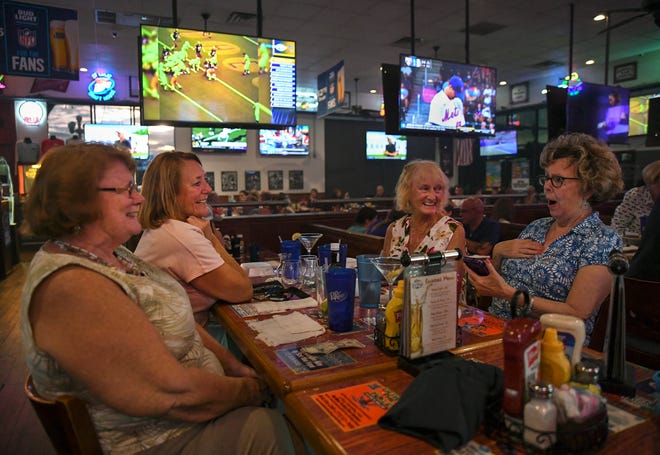 Surrounded by televisions featuring sports and news, Savanna Club residents (from left) Janell Howard, Kathleen Anson, Ginger Dunn, and Diane Fraser socialize after dinner on burger night at the St. Lucie Draft House on Wednesday, Aug,. 31, 2022, in Port St. Lucie. "We love coming here because we've never had a bad meal, the food is excellent, the service is excellent, and we love our lemon drop martinis," Fraser said.