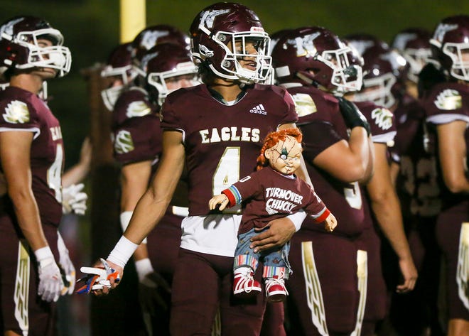 Jayden Sheppard carries Turnover Chucky before the Eagles take the field during the Niceville homecoming football against Gadsden County.