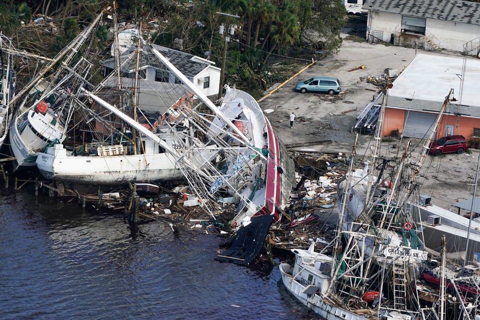In this aerial photo, damaged boats and debris rest against the shore in the aftermath of Hurricane Ian, Thursday, Sept. 29, 2022, in Fort Myers, Fla.