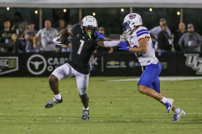 Oct 5, 2022; Orlando, Florida, USA; UCF Knights wide receiver Javon Baker (1) runs the ball against Southern Methodist Mustangs safety Nick Roberts (22) during the second half at FBC Mortgage Stadium. Mandatory Credit: Mike Watters-USA TODAY Sports