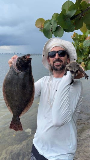 Sonny East of Fort Pierce pulling off a Florida man photo Spt. 26, 2022 before Hurricane Ian's arrival by catching a flounder and a raccoon kit.