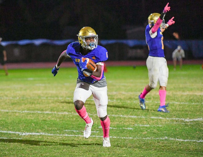 Cardinal Newman safety Vinny Pierre (5) returns an interception for a touchdown during the third quarter of a 40-7 victory over John Carroll Monday night in West Palm Beach.