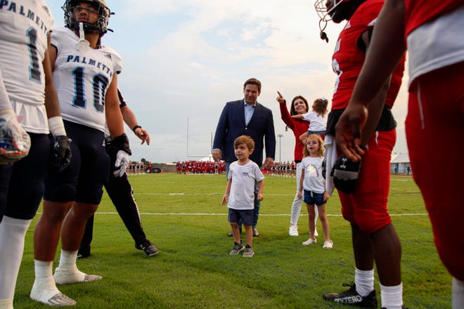 Gov. Ron DeSantis’ son, Mason, tosses a coin at the start of a football game between Vero Beach and Miami Palmetto on Friday, Sept. 23, 2022 in Sebastian. The football game, originally to be held at Billy Living’s Football Field, was moved to Shark Stadium due to the conditions of Vero’s field.