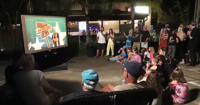 A large crowd gathers around a large TV at Panheads Pizzeria in New Smyrna Beach, Friday night September 9, 2022, to watch the airing of Panherads Pizzeria's episode on Diners, Drive-in and Dives.