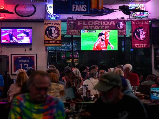 Sports memorabilia and televised sports are seen along the walls at the St. Lucie Draft house in Port St.Lucie on Wednesday, Aug. 31 2022, as diners enjoy their food and conversations on burger night.