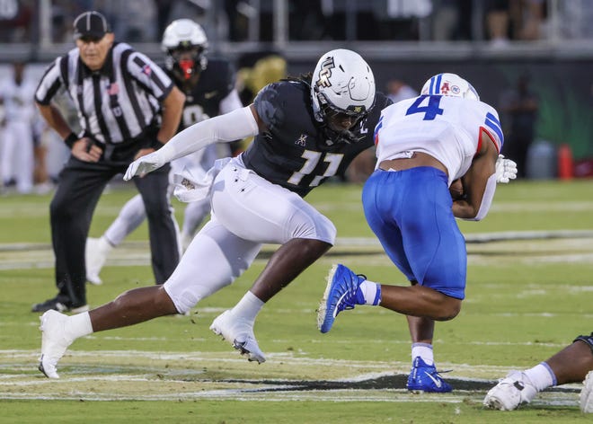 Oct 5, 2022; Orlando, Florida, USA; UCF Knights linebacker Jeremiah Jean-Baptiste (11) moves in for the tackle against Southern Methodist Mustangs running back Tre Siggers (4) during the second quarter at FBC Mortgage Stadium. Mandatory Credit: Mike Watters-USA TODAY Sports