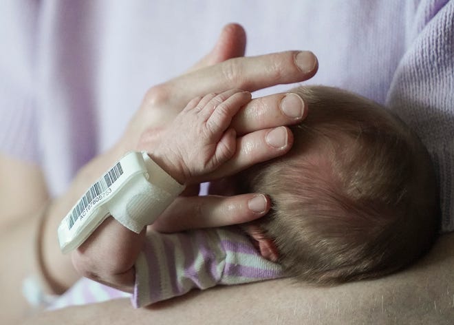 Kali Hyland, of Lehigh Acres in Lee County, Fla., caresses her 3-week-old daughter Amara Fagan's head while she holds onto her hand Tuesday, Oct. 4, 2022, at Cleveland Clinic Tradition Hospital in Port St. Lucie.