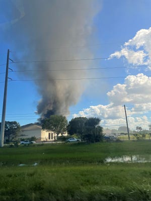 A fire at Hades Motorsports in the 700 block of Southwest Grove Avenue in Port St. Lucie, just east of Florida’s Turnpike and just north of Southwest Crosstown Parkway, can be seen in the distance Oct. 6, 2022.