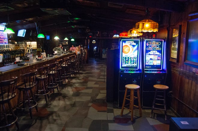 Gaming machines (right) are seen along with patrons and the bartenders while socializing with their drinks at the Boozgeois Saloon, on Thursday, Aug 12, 2022, in Fort Pierce. "It's just a big old melting pot and it's a local dive bar," said bar manager Kyla Wickard. "We all pretty much family in here."