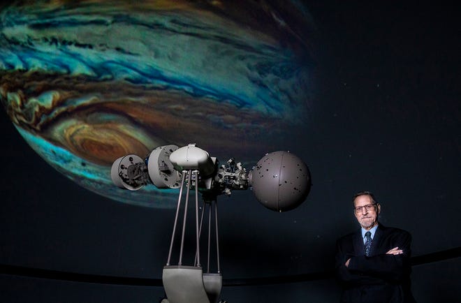 Jon Bell, the director of IRSC's Hallstrom Planetarium in Fort Pierce since it opened in 1993, stands in front of the 360-degree immersive digital OmniStar projection system and the state-of-the-art Spitz automated planetarium projector used to recreate the sky, sun, moon and planets among the stars on the 40-foot, domed ceiling during planetarium shows.