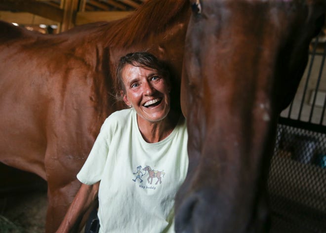 Sharon Massaglia, vice president of the Trailside HOA, tends to a horse Wednesday, Aug. 31, 2022, at the Trailside gated ranchette community in Martin County. Massaglia and other residents have become fearful of the activities taking place on the adjacent private and publicly-owned lands in Pal-Mar and Hungryland natural areas.