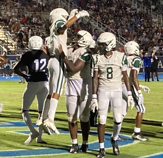 Miami Central players celebrate Sekou Smith's third quarter touchdown against IMG. Central won 20-14.