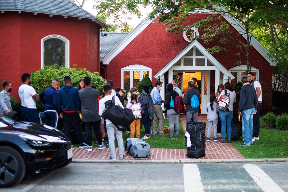 Immigrants gather with their belongings outside a church on Sept. 14, 2022, in Edgartown, Mass., on Martha's Vineyard. Local leaders say two plane landings here appear to be carrying Venezuelan nationals sent to Massachusetts by Florida Gov. Ron DeSantis.