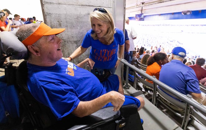 UF football fan Mike Bonner, left, celebrates a big play by the Gators during the South Carolina game on Nov. 12. Bonner, who has cerebral palsy, always has struggled to get into Florida Field and to his seats.