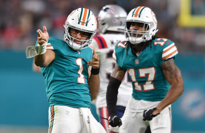 Miami Dolphins quarterback Tua Tagovailoa (1) celebrates after running for a first down against the New England Patriots early in the fourth quarter with teammate wide receiver Jaylen Waddle (17) at Hard Rock Stadium in Miami Gardens, Jan. 9, 2022.