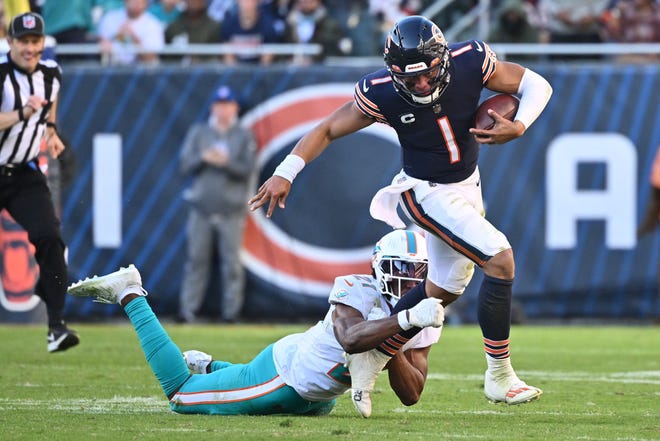 Dolphins safety Eric Rowe lunges but cannot bring down Bears quarterback Justin Fields, who rushed for 178 yards, an NFL record for quarterbacks.