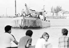 Friends and relatives of Cuban refugees line the dock in Key West, Fla., in this April 30, 1980, photo, as another boat heads into the U.S. Customs docking area as part of the Mariel boatlift. AP photo