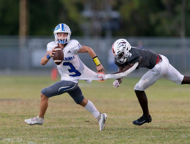 Wellington quarterback Ryan Anthony slips away from Palm Beach Central's Kerlson Jean during their game Friday in Wellington. The Welly Cup game pits Anthony against Central's quarterback Ahmad Haston.
