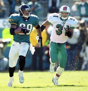 Jacksonville Jaguars running back Fred Taylor (28) breaks out on a 90-yard touchdown run with Miami safety Brock Marion (31) in hot pursuit during the first quarter of the AFC Divisional Playoffs against the Miami Dolphins at Alltel Stadium, Saturday, Jan. 15, 2000. [Bob Self/Florida Times-Union