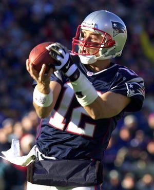 Patriots quarterback Tom Brady gathers in a pass from running back Kevin Faulk for a gain of 23 yards against the Miami Dolphins during the first quarter in Foxboro, Mass. Saturday, Dec. 22, 2001.