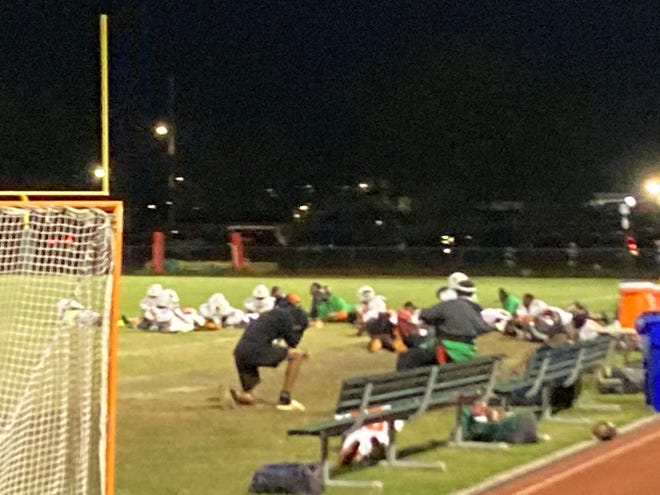 Jones High School football players and coaches hide on the field after a shooting during the Tigers' playoff game against Wekiva on Saturday, Nov. 12, 2022 in Orlando.