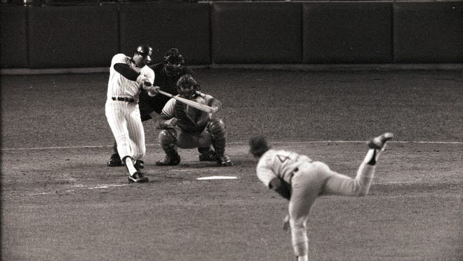 New York Yankees slugger Reggie Jackson hits the first of his three home runs off Burt Hooton of the Los Angeles Dodgers in the fourth inning of Game 6 of the World Series, Oct. 18, 1977, at New York's Yankee Stadium.  Jackson's three home runs helped to an 8-4 win, clinching the World Series championship.  (AP Photo)