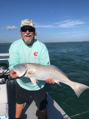 Paul Fafeita holding a redfish catch in the Indian River Lagoon.