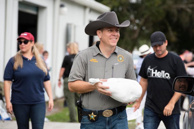 “We are partners with Operation Hope and couldn’t do our jobs without the non-profits in our community. We couldn’t have a safe and beautiful Indian River County without places like Operation Hope,” said Indian River County Sheriff Eric Flowers (center), who helped distribute turkeys and chickens Saturday, Nov. 20, 2021, during Operation Hope’s annual Thanksgiving drive-up food distribution in Fellsmere.