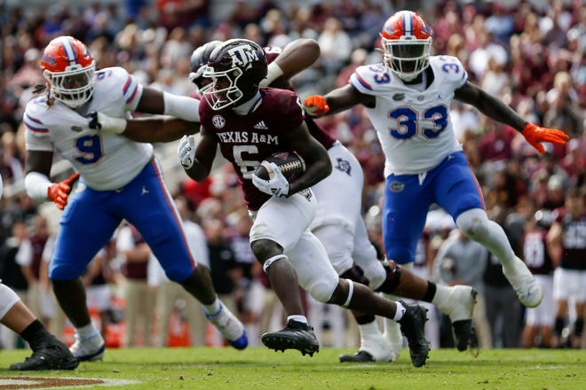 Texas A&M running back Devon Achane tries to run the ball against the Florida defense Saturday in College Station, Texas.