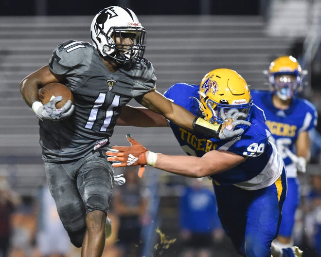 Treasure Coast's Jamison Davis (11) fends off Martin County's Alexander McPherson (99) in a Region 3-4S quarterfinal football game, Friday, Nov. 11, 2022, in Stuart. Treasure Coast won 35-7.