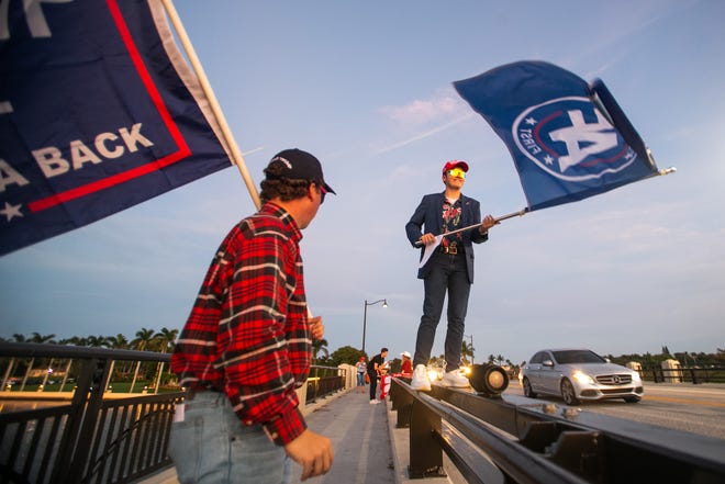 A pair of supporters of former President Donald Trump at the Southern Boulevard Bridge that leads to Palm Beach on Tuesday, November 15, 2022.