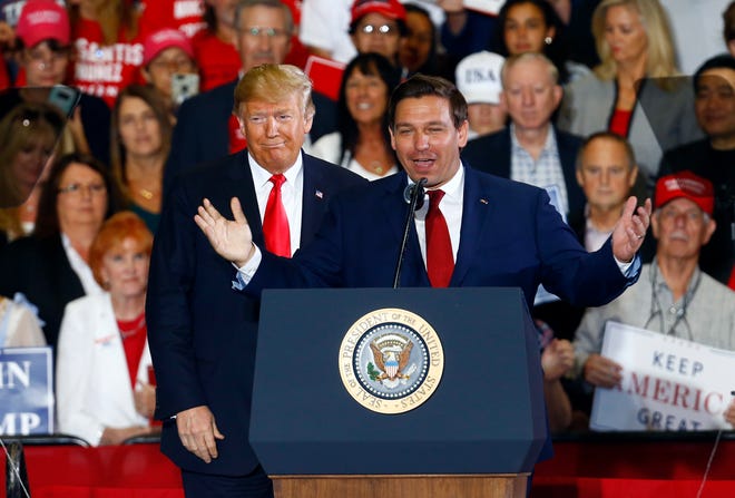 President Donald Trump stands behind Ron DeSantis, Candidate for Governor of Florida, as he speaks at a rally, Saturday, Nov. 3, 2018, in Pensacola, Fla. (AP Photo/Butch Dill)