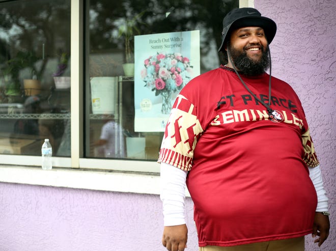 Alexander Tommie, who runs Sylvia's Flower Patch II, stands outside of the shop during a food distribution held before Thanksgiving on Tuesday, Nov. 22, 2022, in Fort Pierce in memory of his mother, Sylvia Tommie. The group handed out turkeys, green beans and corn to the Lincoln Park community.