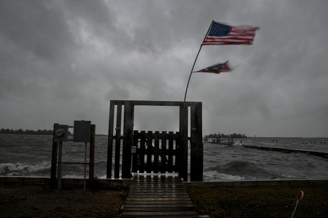A tattered American flag is seen flapping in the wind at a dock along the Indian River Lagoon in St.Lucie Village on Wedneseday, Nov. 9, 2022, as Tropical Storm Nicole approaches Florida. The storm became a hurricane before moving inland Wednesday night into Thursday morning along the east coast of Florida.