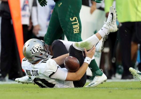 Central Florida quarterback McKenzie Milton goes down with an apparent knee injury after being tackled during the first half of an NCAA college football game against South Florida on Friday, Nov. 23, 2018, in Tampa, Fla. (