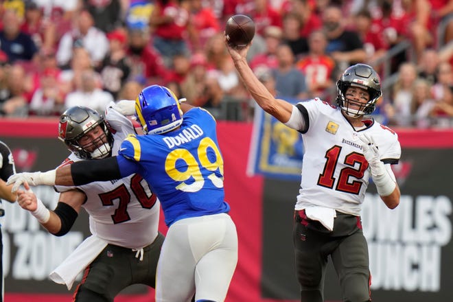 Tampa Bay Buccaneers quarterback Tom Brady (12) throws a pass as Los Angeles Rams defensive tackle Aaron Donald (99) tries to get past offensive tackle Robert Hainsey (70) during the first half of an NFL football game between the Los Angeles Rams and Tampa Bay Buccaneers, Sunday, Nov. 6, 2022, in Tampa, Fla. (AP Photo/Chris O'Meara)