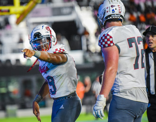 Gibbons running back Kamari Moulton (19) celebrates a tocuhdown alongside tackle Zack Boehly (72) during the Class 4A State Championship game between Cardinal Gibbons and Cocoa at DRV PNK Stadium in Fort Lauderdale, FL., on Thursday, December 16, 2021.